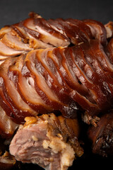Slices of smoked pork on a dark background. 