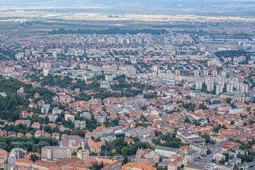 Aerial view of Brasov surrounded by the Carpathian mountains dotted with ski resorts including the ever popular Boiana Brasov. Romania, the Balkans, Eastern Europe