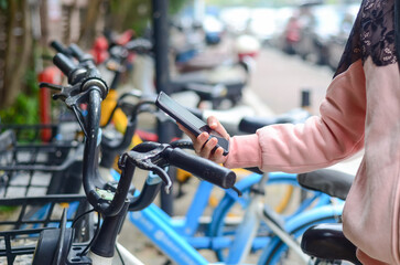 People use smart phone to scan the QR code on a shared bike to unlock it. © rourouguan