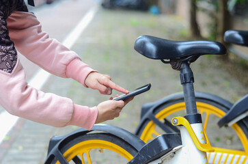 Obraz premium People use smart phone to scan the QR code on a shared bike to unlock it.