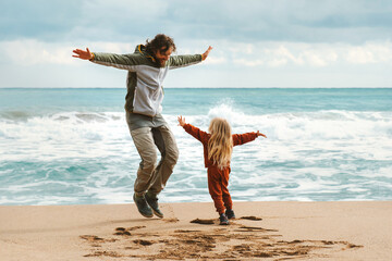 Father and child having fun family lifestyle dad and daughter playing together outdoor walking on the beach, parent and kid on summer vacations Father's day holiday happiness candid emotions