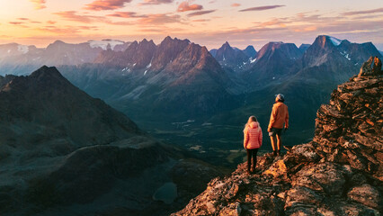 Couple friends climbing mountains in Norway man and woman traveling together, active vacations healthy lifestyle family hiking outdoor extreme adventure trip in Lyngen Alps, people enjoying landscape