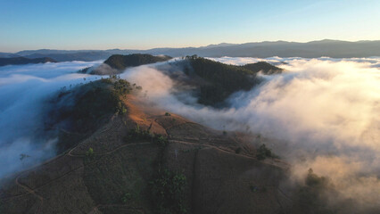Landscape view of the sea of fog flowing on hills at dawn by drone