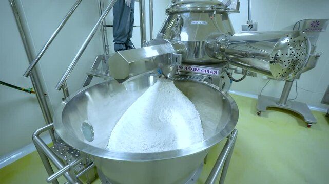 Pharmaceutical powder medicine mixing, blending process. powder chemical pharma ingredient in a large industrial equipment production line in a pharma manufacturing plant factory. Granulation process.