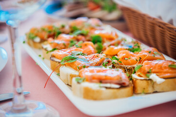 Delicious bruschetta with salmon on a white plate. Salmon toast with cream cheese and microgreens. Healthy food, health benefits, omega 3, fish oil. Natural, delicious and healthy seafood