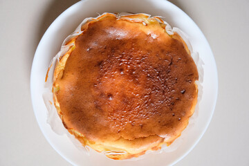 Close-up of homemade basque burnt cheesecake on a white plate.