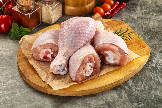 Raw uncooked chicken drumsticks over board