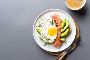 Toast with fried egg, bacon and avocado for breakfast