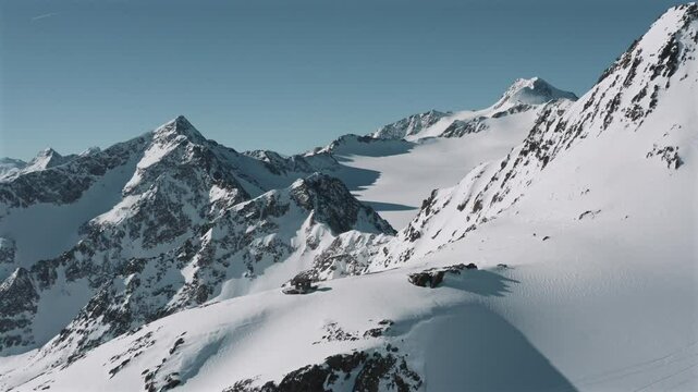 Drone shot of the snow-covered Otztal mountains in the Central Eastern Alps, Austria on a sunny day