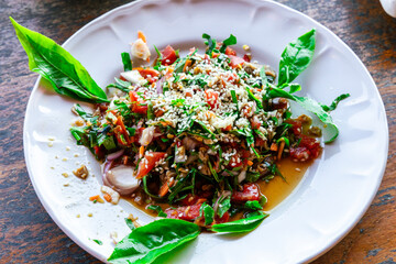 Spicy Tea leaf salad on white disc