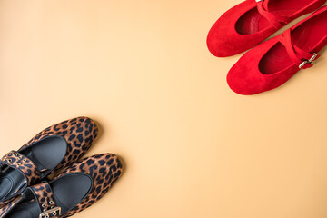 Leopard and red ballet flats on beige background with copy space