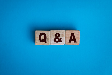 question and answer or q and a letter symbol on wooden blocks isolated on blue background