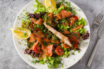 Salad with smoked salmon on stone table. Healthy eating concept