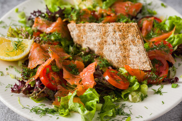 Salad with smoked salmon on stone table. Healthy eating concept