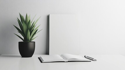Fototapeta premium Minimalist workspace featuring a plant notebook and picture frame