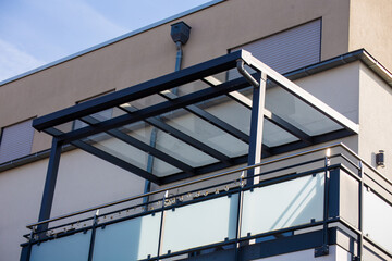 Schöne Balkonüberdachung aus Glas und Aluminium an einem Wohnhaus