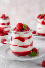 Vanilla white chocolate mousse, trifle, panna cotta or parfait with raspberry sauce in a glass jar. Sweet summer dieting dessert.