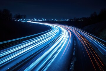 Night Highway Curves with Light Trails; Cityscape in Background.  Possible use Stock photo for transportation, travel, or urban landscapes