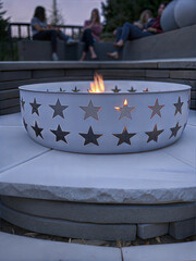 White fire pit with star cutouts on a patio