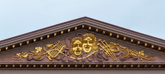 Golden decorative frieze with masks and scrolls, theather, symbol for art