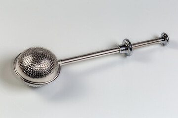 Stainless steel tea strainer for tea brewing on a gray background