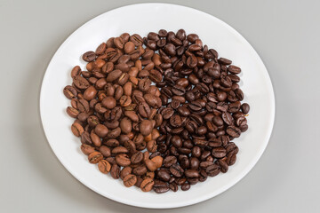 Medium and dark roasted coffee beans separately on one plate