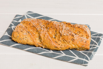 freshly baked bread with napkin on rustic table top view. Healthy white bread loaf isolated