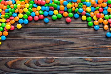 Obraz premium Mixed collection of colorful candy, on colored background. Flat lay, top view. frame of colorful chocolate coated candy