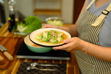 Cropped shot of adult woman serving a nutritious vegetable dish in a kitchen