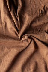 Obraz premium Close-up of soft brown fabric with elegant folds and textures, ideal for backgrounds or textile-related designs.
