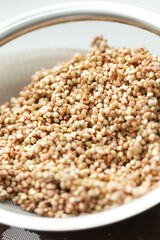 Buckwheat Groats in Strainer - Close-up of toasted buckwheat seeds ready for cooking, showing texture, color and preparation stage