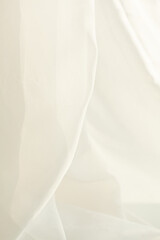 Soft, flowing ivory fabric creates a sense of ethereal movement and subtle elegance with its gentle folds and delicate texture.