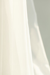 Soft, sheer fabric gently drapes with flowing lines, bathed in the soft glow of natural light creating a sense of tranquil elegance.