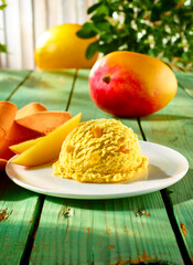 Mango Melonen Eiskugel auf Telller und gruenem rustikalem Holzfond mit Busch, Eiscreme, Eiskugel, Fruchteis, 
