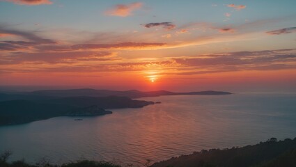 Obraz premium sunset over tranquil sea with silhouette of distant islands under a colorful sky with clouds and reflection on water surface