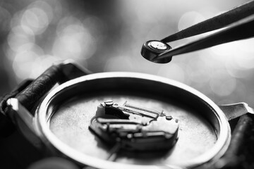 Clockmaker repairing broken watch at table, closeup