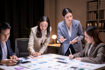 A group of people are sitting around a table with papers and pens