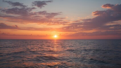 Obraz premium Sunset over calm ocean water with colorful sky and clouds reflecting light in the evening.