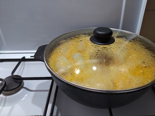 Cooking soup in a pot on a gas stove, close-up