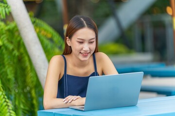 Young Asian Woman Using Laptop, Enjoying Digital Lifestyle Outdoors a Modern City