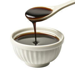 Rich soy sauce drizzles from spoon into small white bowl, showcasing its dark, glossy texture. Perfect for enhancing flavors in various dishes