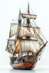 Fototapeta premium Detailed Wooden Ship Model with Aged Sails on White Backdrop Capturing the Essence of Maritime History and Nautical Adventure in Still Life