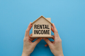 A wooden house with the word Rental Income written on it