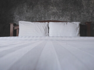 Vintage bedding over grunce concrete wall i bedroom.