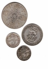 The reverse of antique coins from Great Britain from the 20th century on a white background.
