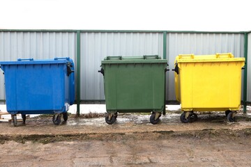 Container for separate garbage collection. Close up photo of three recycle bins on the city street...