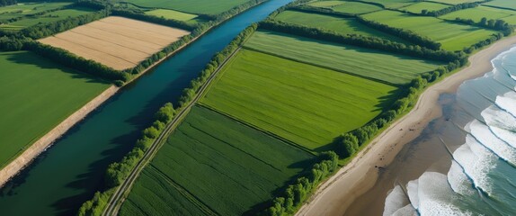 Aerial view of lush green fields, meandering river, and sandy beach with ocean waves along the coastline during daytime.