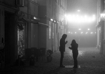 A misty fog in a city with two dark siluets