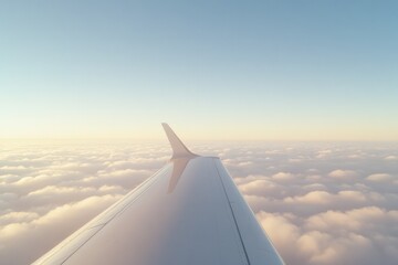 Fototapeta premium Airplane wing glides above fluffy clouds during serene sunset, s
