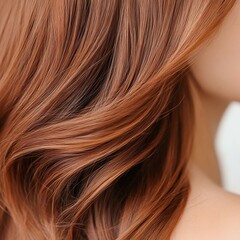 Fototapeta premium Close-up of beautiful, flowing hair in soft shades of brown and copper, showcasing healthy strands and elegant curls.